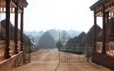 Entrée de la chefferie Bandjoun, près de Bafoussam ; les cases des femmes se trouvent de chaque coté de l'allée principale qui conduit à la grande case palais-temple royale